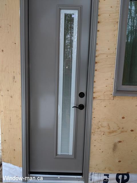 Single Eentry door. Very narrow door 24 inch. Custom color. Asymmetrical glass with internal tilt and lift mini blinds. Meditation cabin in the woods. Storm color
